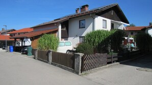 A residential house with a sloped roof, a fenced yard, and a parked white van. - Apartment 'Schopper' with Balcony and Wi-Fi (Halblech)