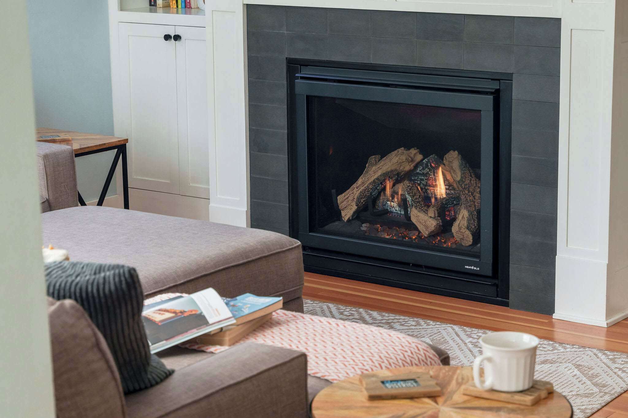 Una sala de estar con chimenea, un sofá, una mesa de centro y una estantería.