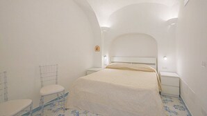 Une chambre à coucher comprenant un lit, une chaise, une table de chevet et une petite table.