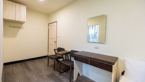 A small, clean room with a desk, two chairs, a bed, a wardrobe, and a mirror on the wall. - Green Field Mountain Villa (Taoyuan City)