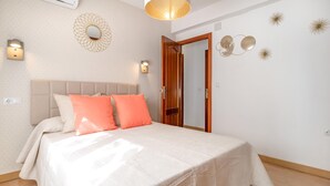 Ein Schlafzimmer mit Bett, Kopfteil, Tür und Wanddekoration.