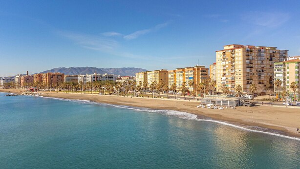 Eine Küstenstadt mit Strandhotels, Palmenalleen und freiem Blick auf den Ozean.