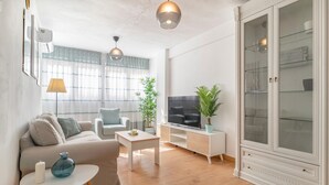 Ein modernes Wohnzimmer mit einer Couch, einem Couchtisch, einem Fernseher und einem Schrank.