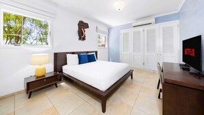 Una habitación de hotel con cama, televisión, escritorio y armario.