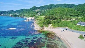 A coastal area with a beach, clear water, and green hills. - Rental cottage Santorope (Kyotango)