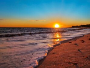 Enjoy a serene beach experience with gentle waves lapping the shore.