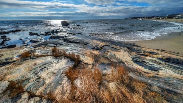 A rocky shoreline with a beach and ocean in the background. - The Stern at Soundview · Beach+Ocean+Sunrise (Old Lyme)