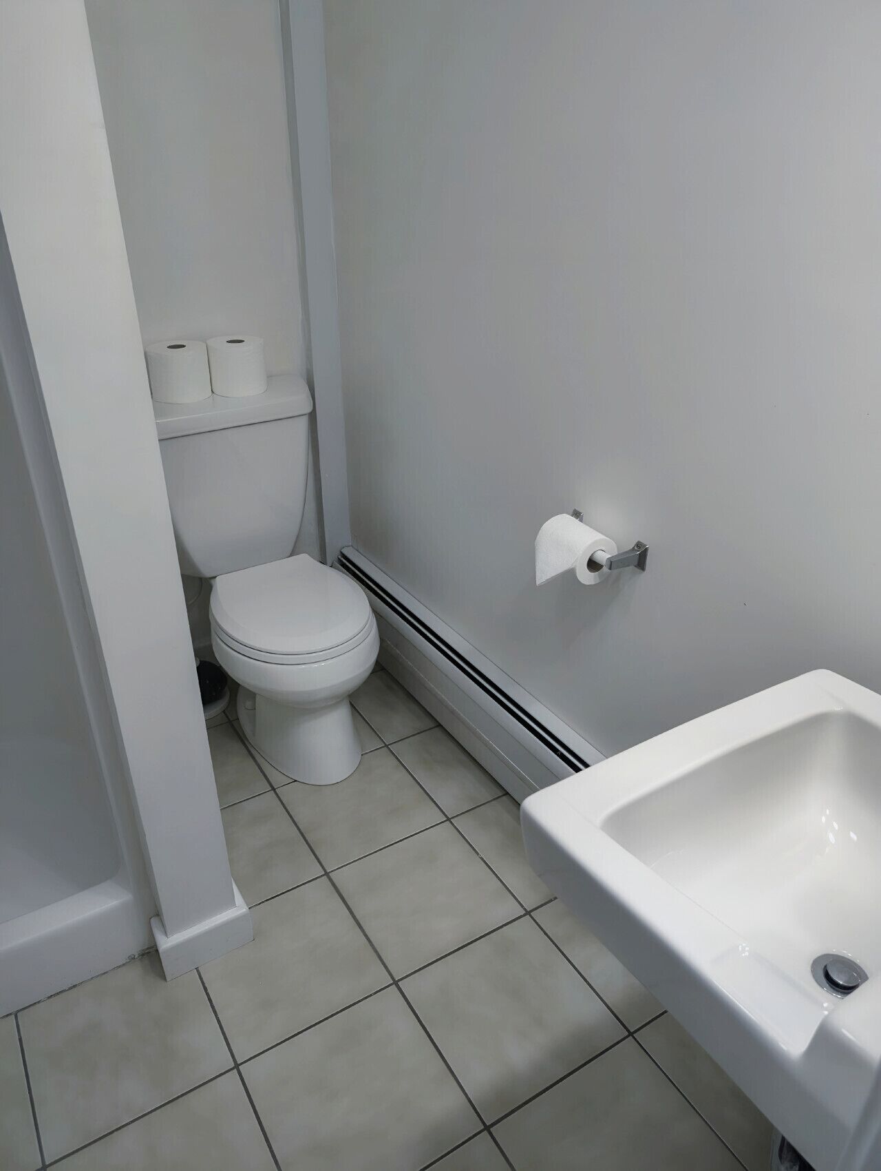 A bathroom with a toilet, a bidet, and a white sink.
