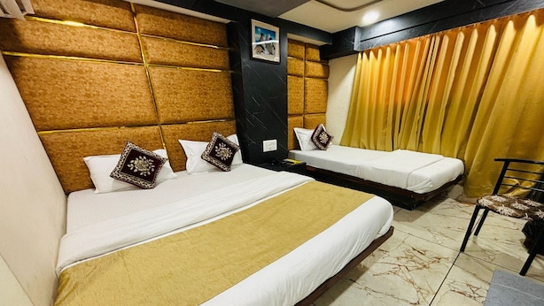 Habitación de hotel con dos camas, un sofá, una silla y una mesita.