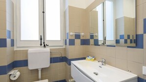 A bathroom with a toilet, sink, and mirror. - Housestation S (Palermo)