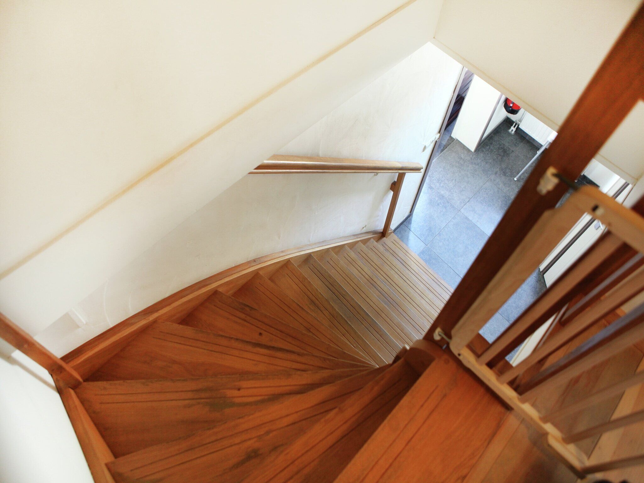 Un escalier en bois, doté d’une rampe, mène à un palier.