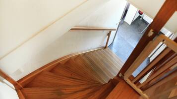 Un escalier en bois, doté d’une rampe, mène à un palier.