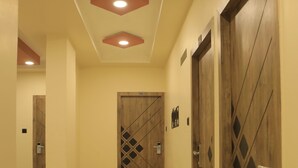 Un pasillo con puertas de madera, cada una con un número, que conducen a habitaciones.
