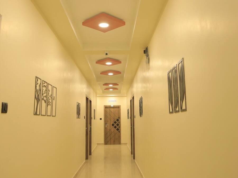 A hallway with a polished floor, recessed lighting, and artwork on the walls.