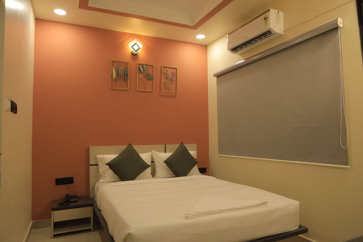Un dormitorio con cama, mesita de noche, aire acondicionado de pared y ventana con persiana.