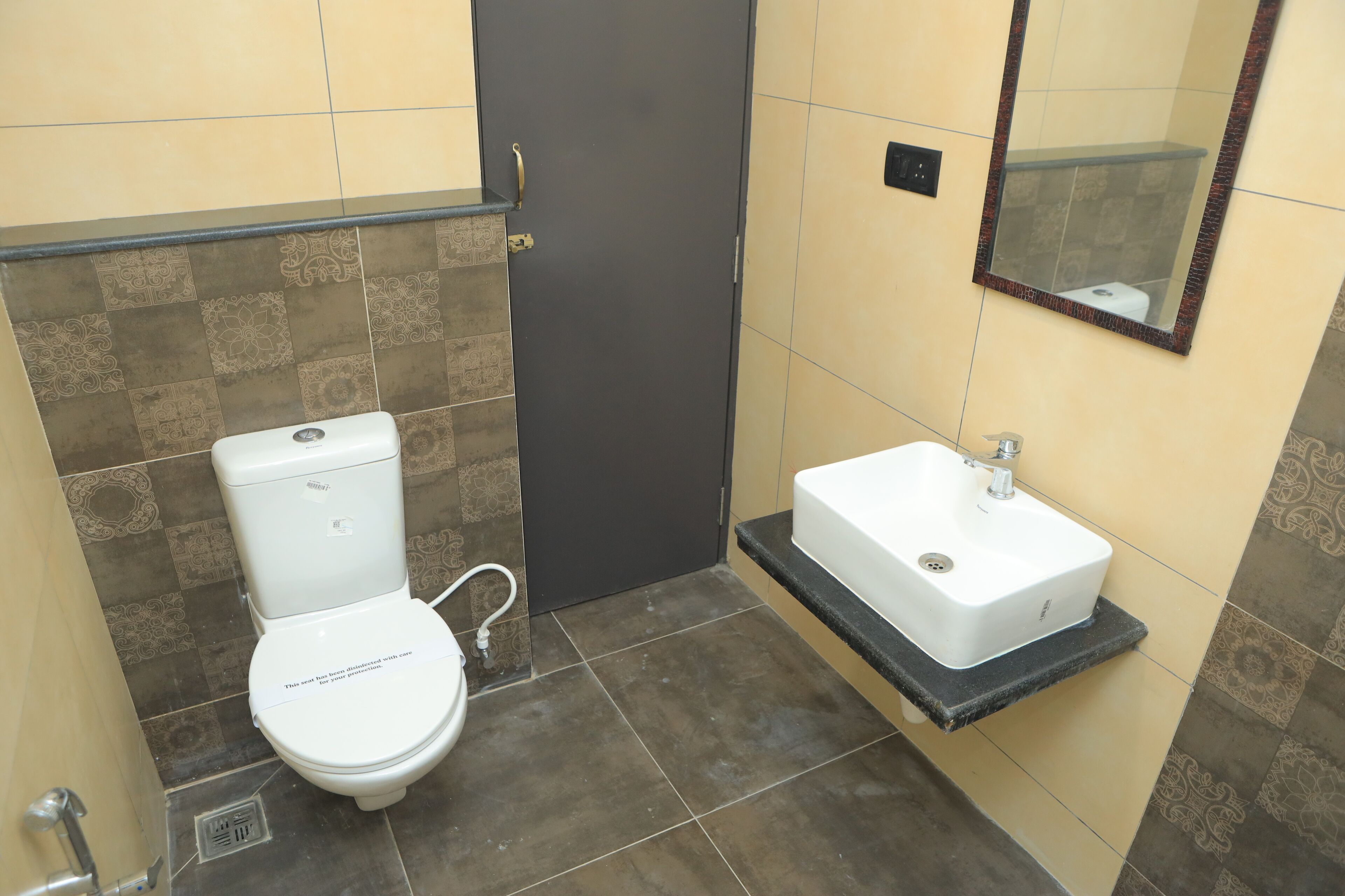 Un baño con inodoro, lavamanos y espejo.