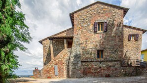 A stone building with a sloped roof, a small window with shutters, and a gravel driveway. - Montaione Harmony: Lodging (Varna - Gambassi Terme-Fi)