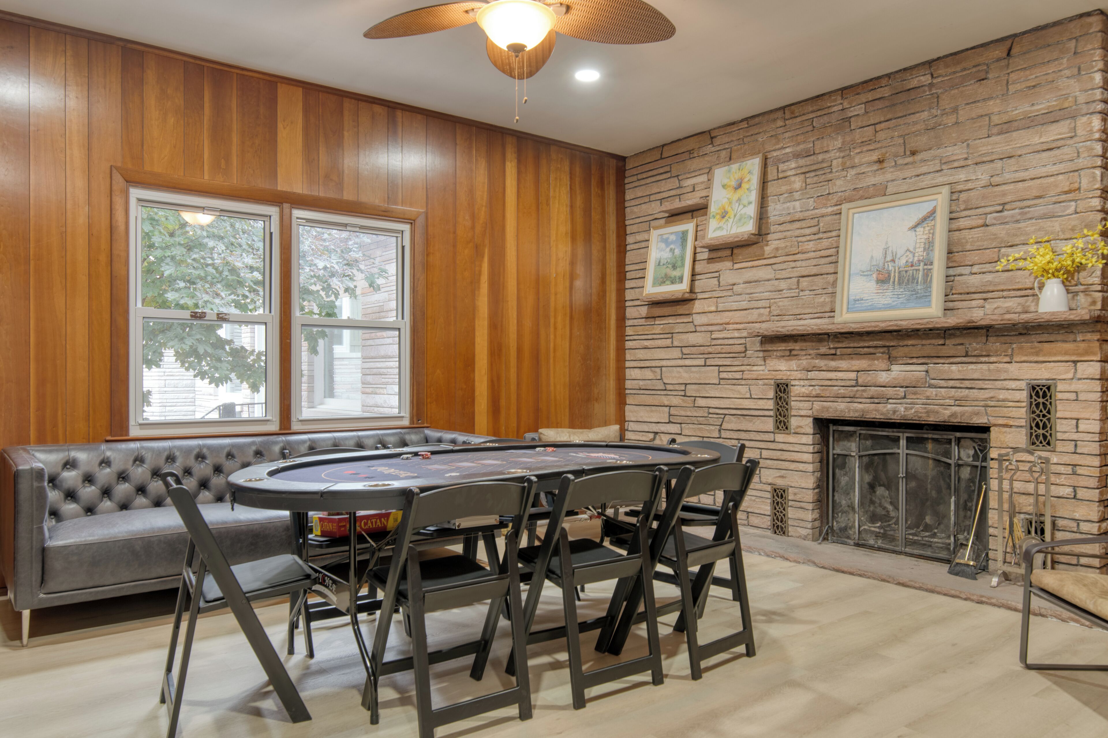 A room with a fireplace, a stone wall, and a round table with chairs.