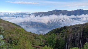 A panoramic view of a mountainous landscape with a valley and a lake.