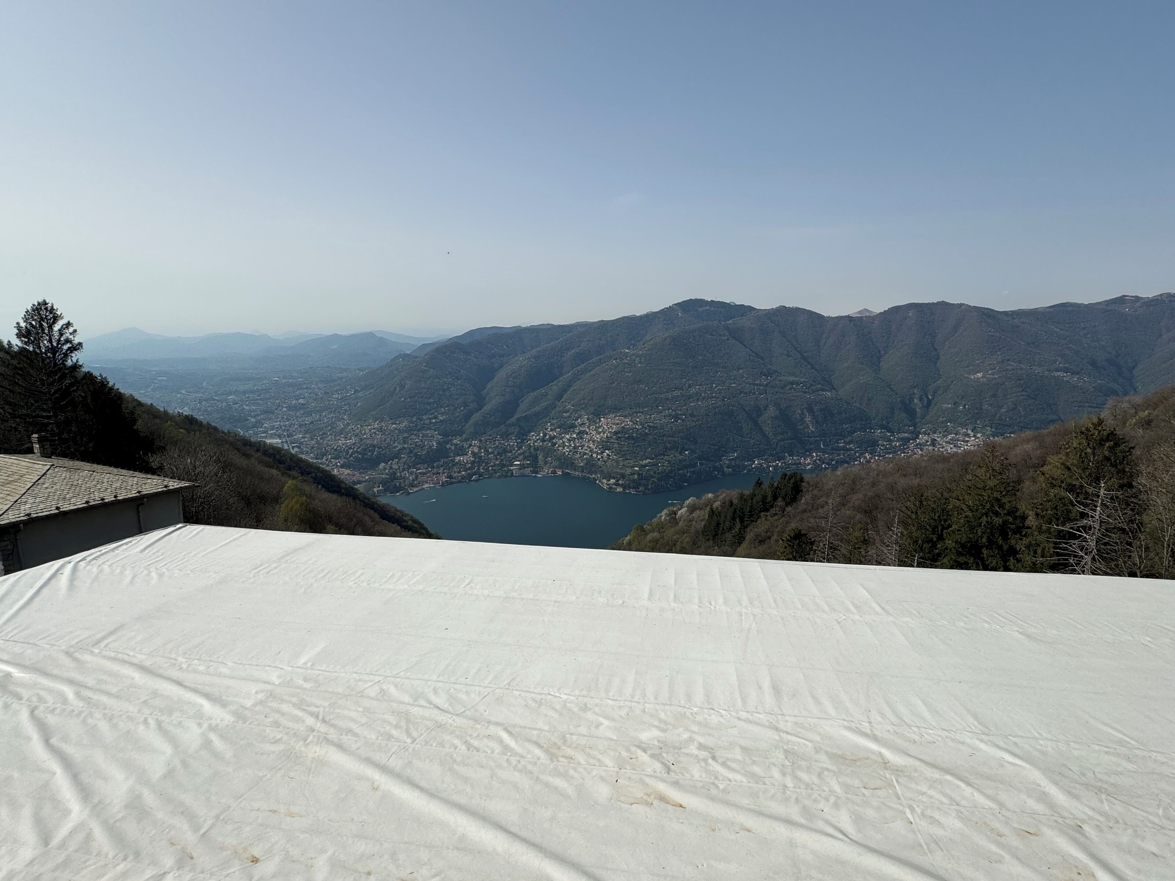 Panorama di un paesaggio montuoso con un lago e una città in basso.