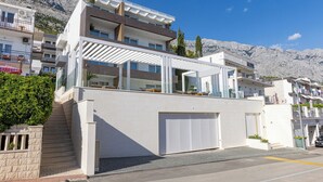 Ein modernes, zweistöckiges Gebäude mit überdachtem Außenbereich und einer Garage.
