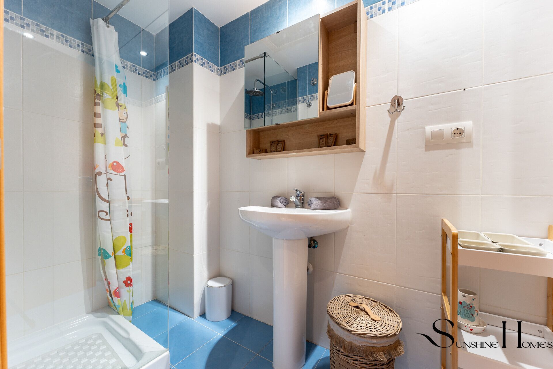 Une salle de bain avec une douche, un lavabo et un miroir.