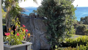 Ein Garten mit Teich, Steinen und einer Holzterrasse.