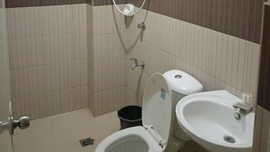Uma casa de banho pequena com sanita, bidé e lavatório.