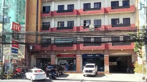 Um edifício de vários andares com uma farmácia e uma lavagem de carros no andar térreo.
