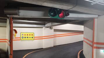 A parking garage with a traffic light, orange lines on the floor, and a sign with Chinese characters.