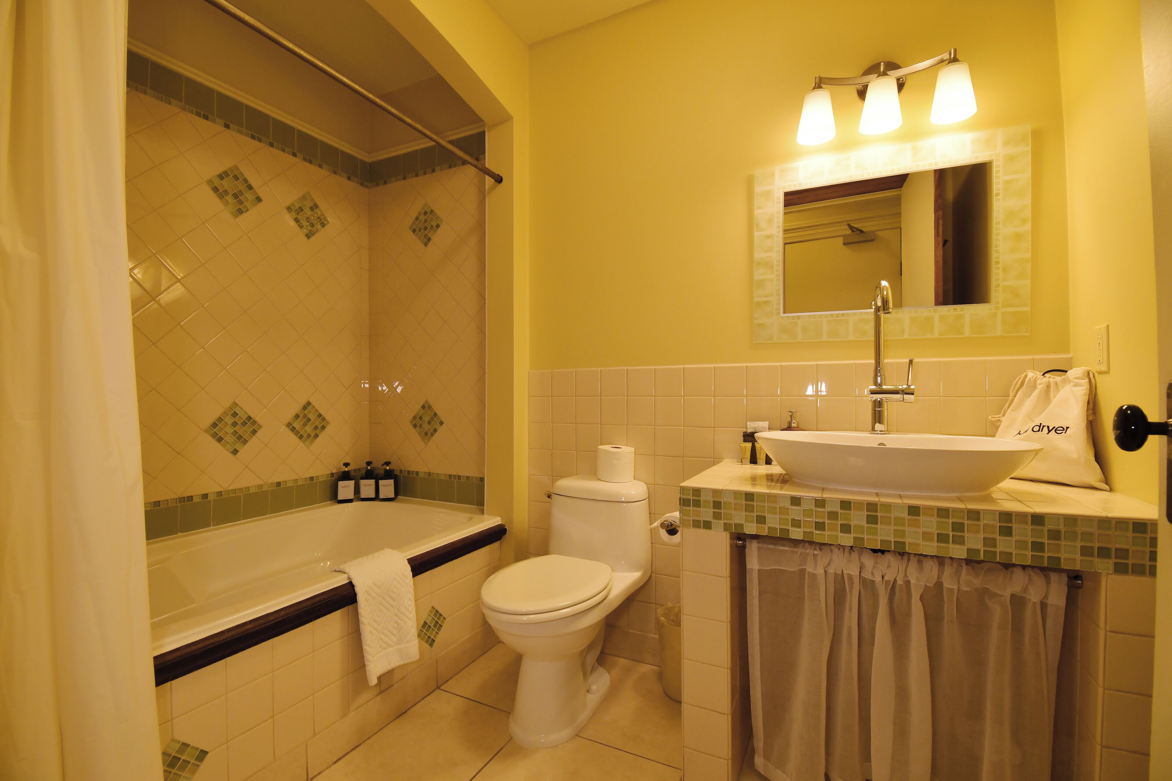 Un baño con bañera, inodoro, lavamanos y ducha.