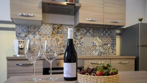 A kitchen with a wine bottle, two glasses, and a basket of fruit. - Housestation  (Palermo)