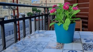A balcony with a blue potted plant and patterned tiles. - Housestation  (Palermo)