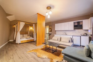 A modern living room with a sofa, a coffee table, and a dining area with a kitchen in the background. - Centrum Residence (Ankara)