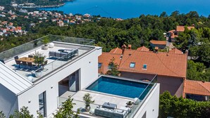 A modern building with a rooftop pool, offering views of a coastal city and surrounding greenery. - Opatija Sky by Interhome (Opatija/Bregi)