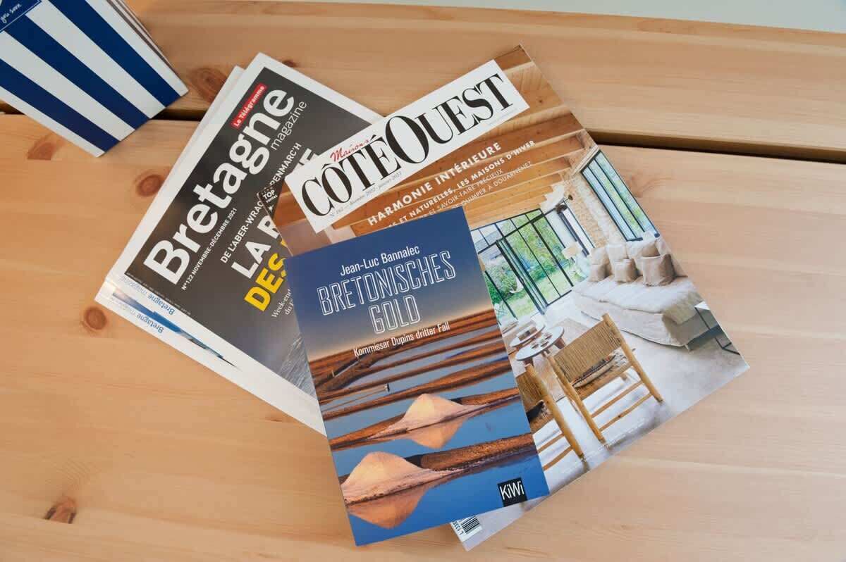 A wooden table with three magazines: 'Bretagne', 'Cote Ouest', and 'Des Bretonsches Gold'.