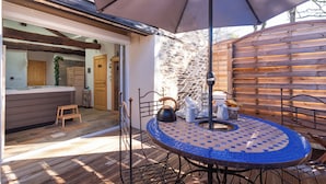 An outdoor patio with a round table, chairs, and a large umbrella. - Le Gîte Spa du Cèdre Bleu Absolute Place of Relaxation and Soothing!  (La Tourette-Cabardès)