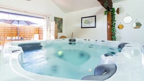 A hot tub with a wooden ceiling and a view of a wooden deck outside. - Le Gîte Spa du Cèdre Bleu Absolute Place of Relaxation and Soothing!  (La Tourette-Cabardès)
