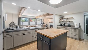 Una cocina moderna con una isla central, encimera de madera y electrodomésticos integrados.
