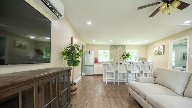 A spacious living area with a sofa, a wooden cabinet, and a ceiling fan. - Historic Oviedo Charmer - Close to everything (Oviedo)