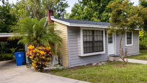 A small, single-story house with a front porch, a garage, and a well-maintained lawn. - Historic Oviedo Charmer - Close to everything (Oviedo)