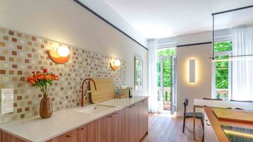 Una cucina moderna con una grande isola, un vaso di fiori e un tagliere di legno.