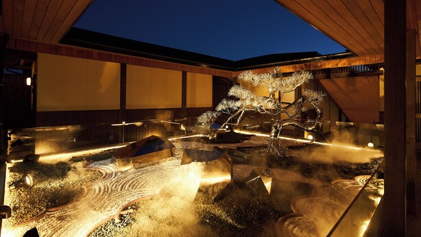 A traditional Japanese garden with a koi pond, wooden walkways, and a lantern. - Villa Ryusei (Shima)