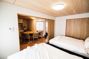 A hotel room with two beds, a dining area with a table and chairs, and a wooden ceiling. - HOTEL Amaranth KyotoGojo (Kyoto)