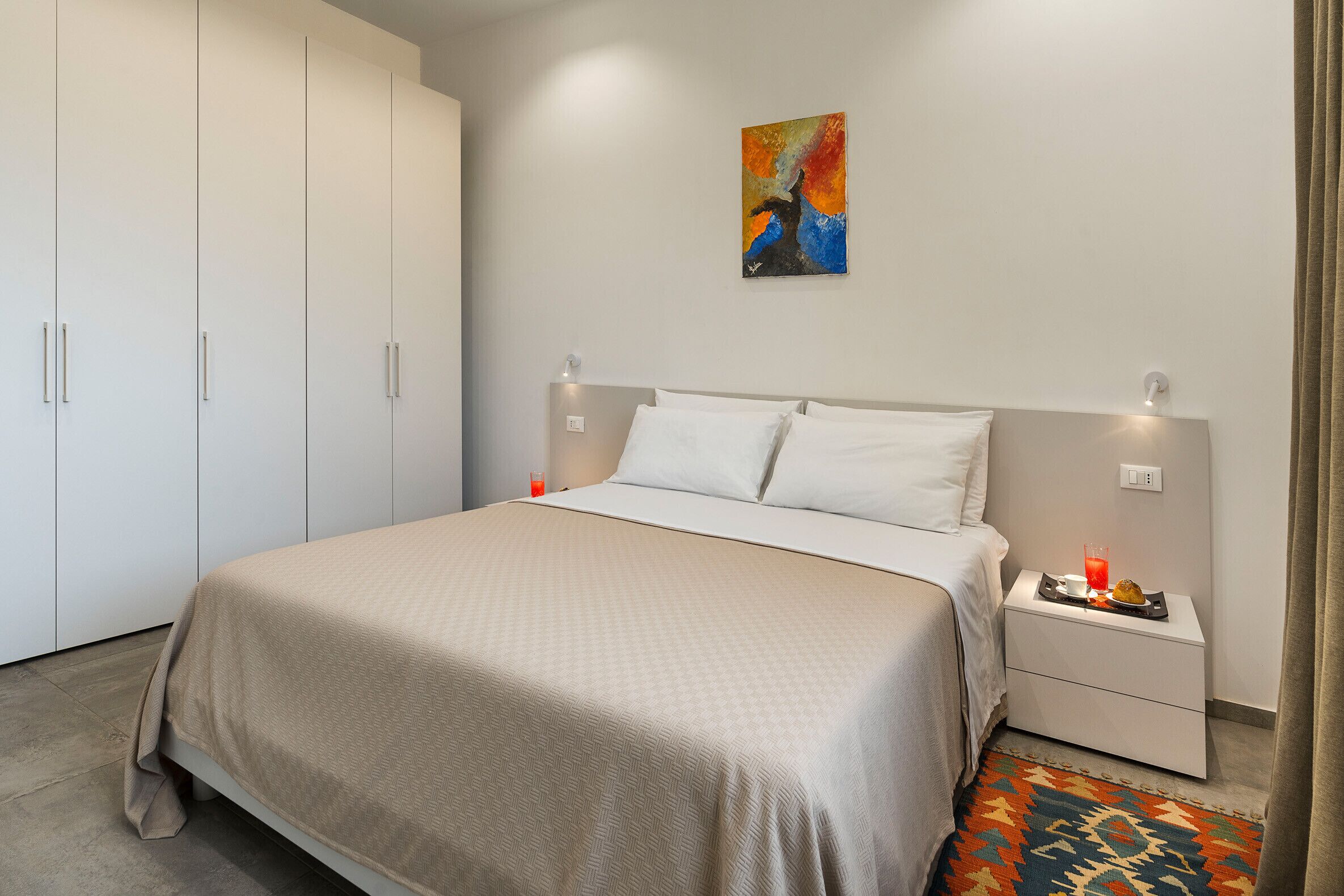 Une chambre à coucher avec un lit, une table de chevet et une armoire.