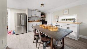 A modern kitchen with a dining table, chairs, and a refrigerator. - "Whitewater-The Genoa" on Oneida Lake/Sleeps 8! (Canastota)