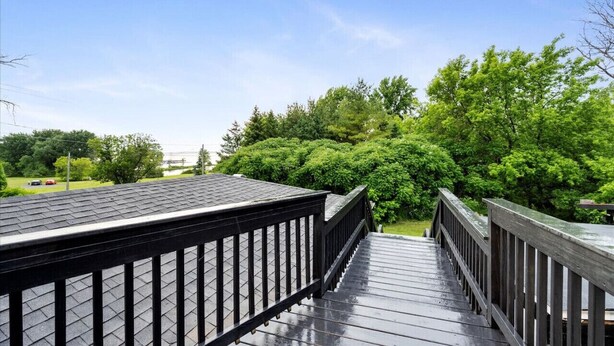 A wooden deck with railings leading to a lush green area. - "Whitewater-The Genoa" on Oneida Lake/Sleeps 8! (Canastota)
