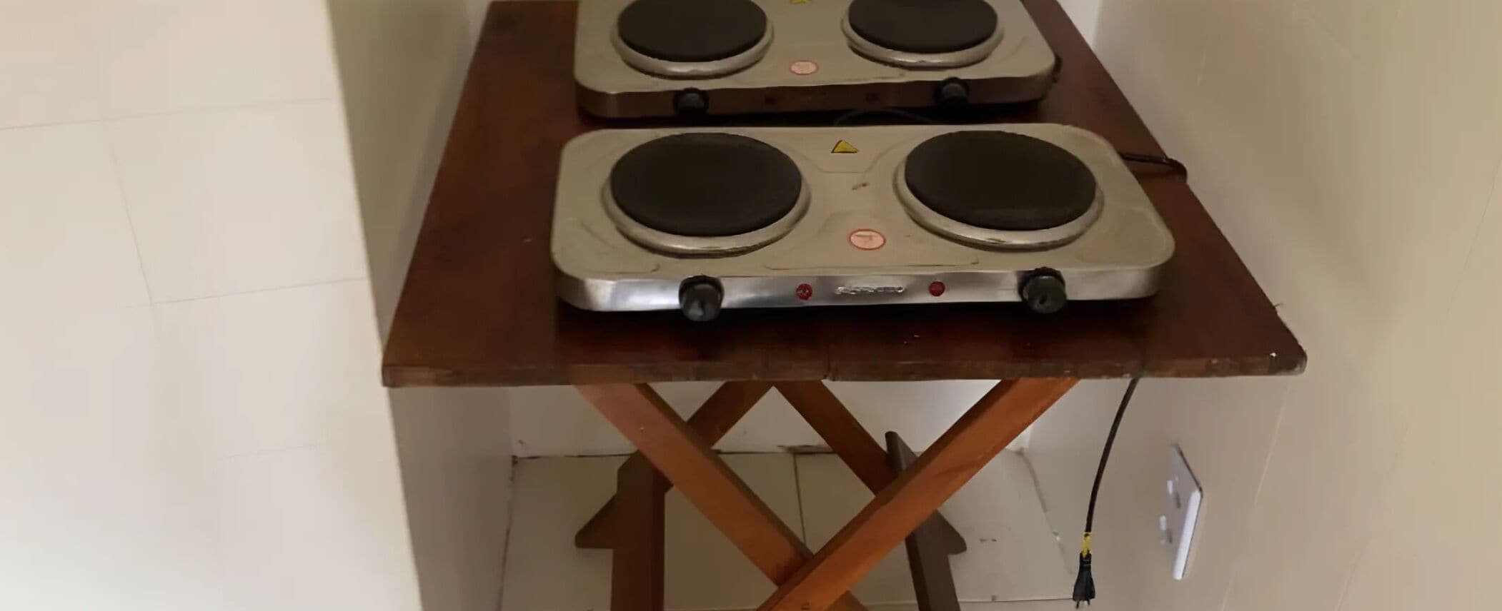 A table with two electric kettles on it.