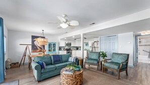 A modern living room with a sofa, chairs, a round coffee table, and a ceiling fan. - Oceanfront Condo | Couples | Cozy (Port St. Joe)