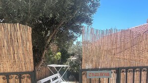 Un área exterior cercada con un banco blanco y una valla de bambú.